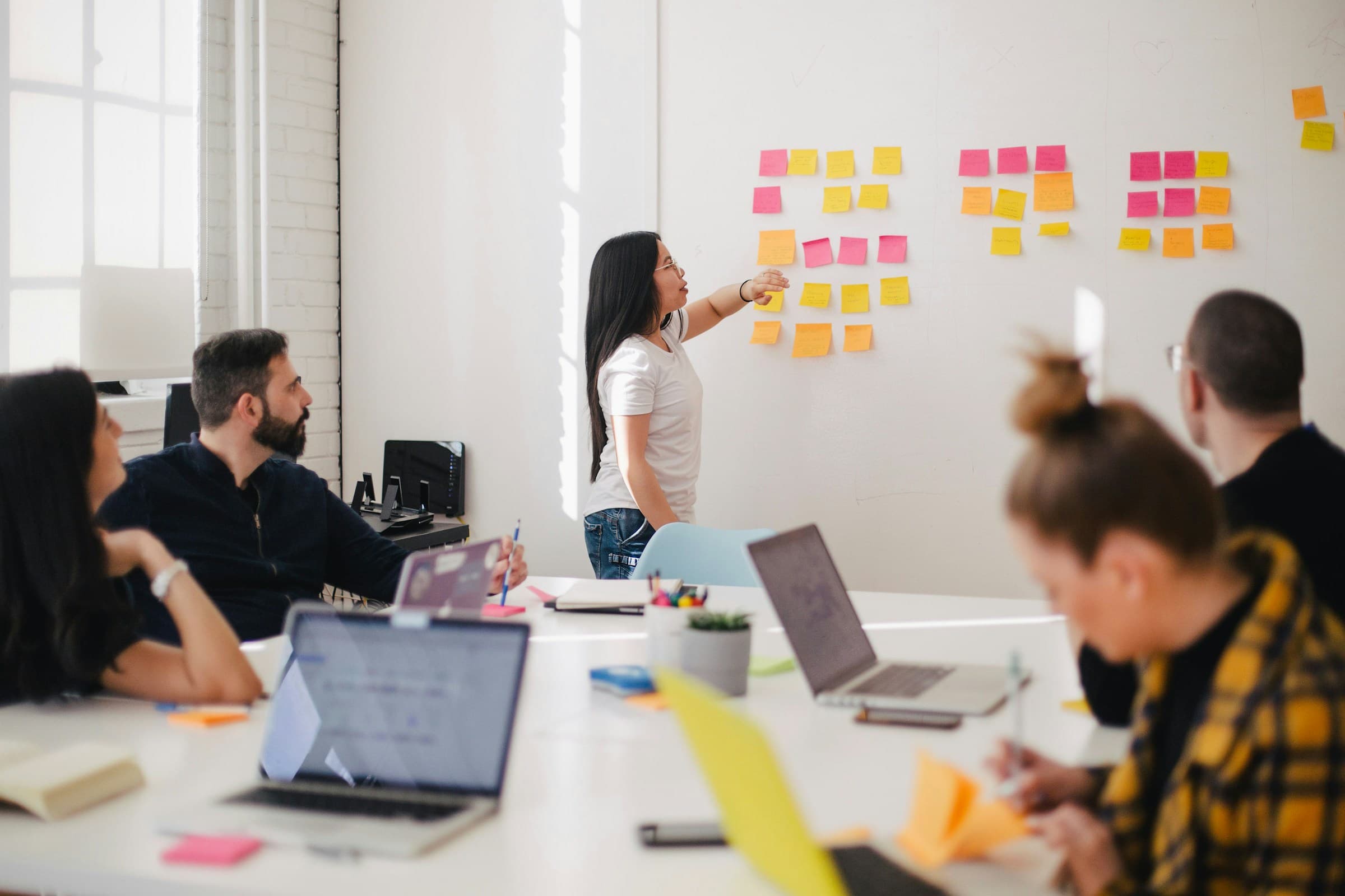 A team reviewing a wall of sticky notes in a stand-up.